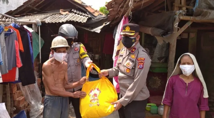 Kapolsek Cikande Kompol Salahuddin saat memberikan bantuan sembako kepada masyarakat yang terdampak pandemi Covid-19. (Foto/Humas Polsek Cikande)