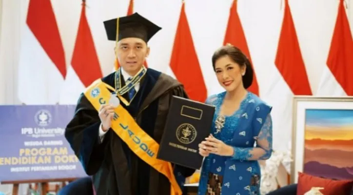 Edhie Baskoro Yudhoyono alias Ibas dengan toga setelah meraih gelar doktor dari IPB, didampingi istrinya, Siti Ruby Aliya Rajasa (doc)