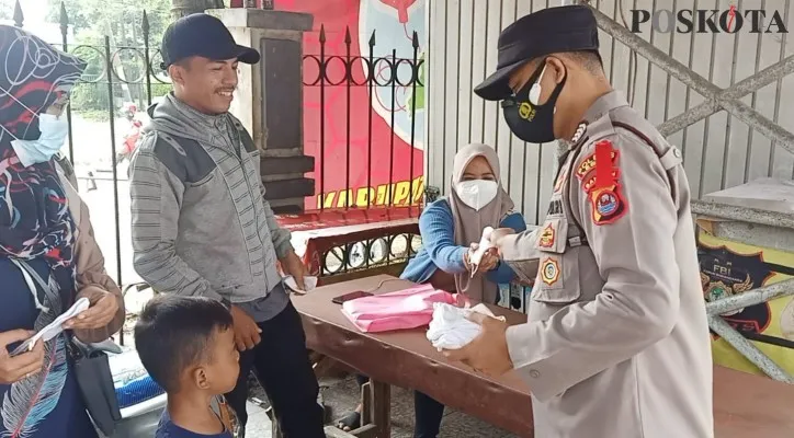 Anggota Polres Lebak membagikan masker kepada di Pasar Rangkasbitung. (Foto/Yusuf)