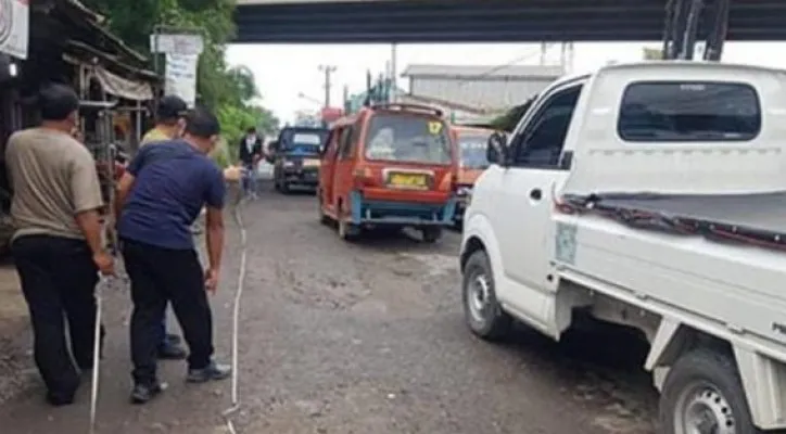 Beberapa warga sedang mengukur jalan rusak yang parah di jalan industri Pasir Gombong, Cikarang Utara (Foto/Ihsan)