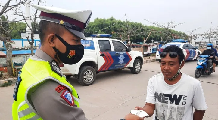 Personel Ditlantas Polda Banten saat menggelar pendisiplinan protokol kesehatan Covid-19 dan membagikan masker kepada pengendara sepeda motor. (foto: ist)