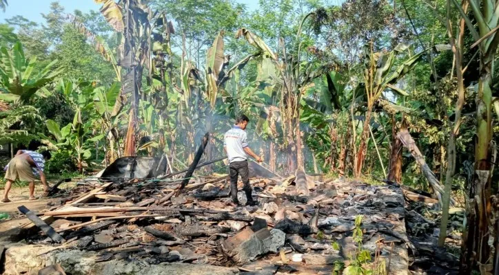 Warga tengah menyiram puing yang masih terbakar. (foto: ist)