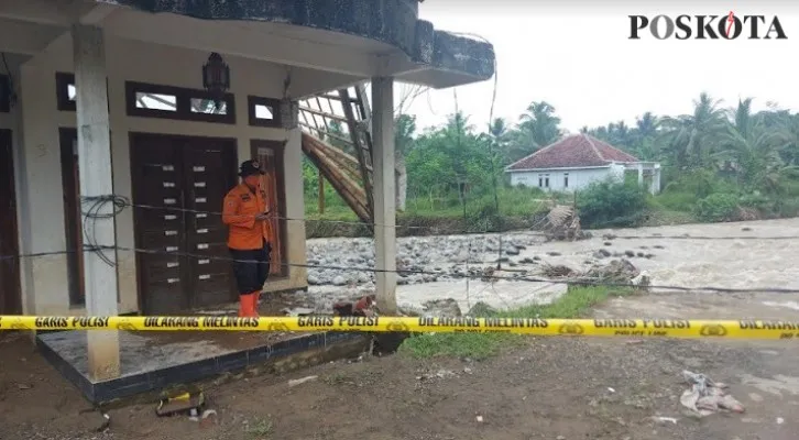 Petugas BPBD Kabupaten Bogor memeriksa rumah warga yang rusak berat dan pihak kepolisian tengah memasang garis polisi. (foto: angga) 