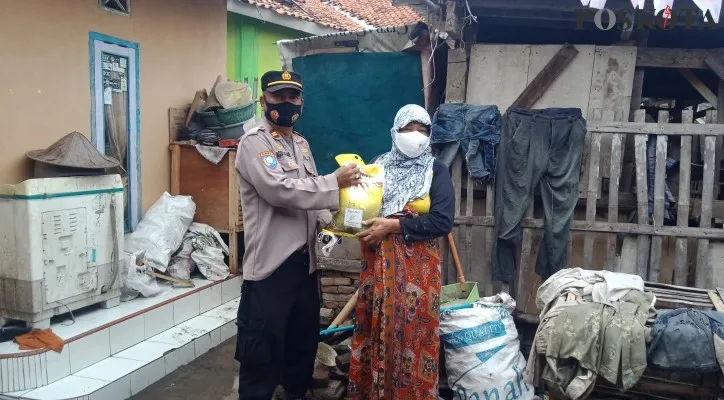 Personel Polsek Kramatwatu saat menyerahkan beras bantuan pemerintah di Desa Toyomerto. (foto: rahmat haryono)