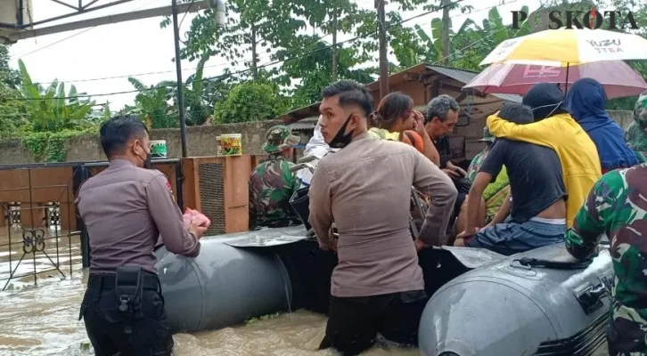 Personil Polres Lebak melakukan evakuasi warga terdampak banjir di Kampung Barambang. (Foto/Yusuf)