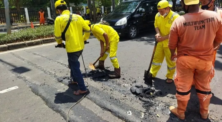 Petugas Sudin Bina Marga Jakarta Timur dan PPSU Kelurahan Kayu Putih sedang membongkar polisi tidur ekstrem yang berada di Jalan Pulo Mas Raya, Kelurahan Kayu Putih, Kecamatan Pulogadung, Jakarta Timur, Minggu (26/9/2021). (Foto/cr02)