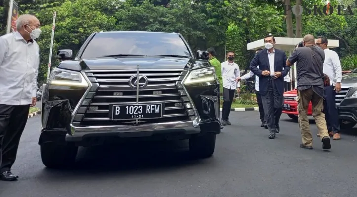 Menteri Luhut Binsar Pandjaitan turun dari mobil Lexus saat datangi Polda Metro Jaya. (Adji)