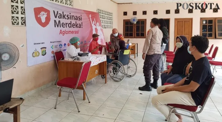 Kapolsek Sawangan, AKP M. Meltha Mubarak membantu menjemput dan mengantarkan seorang lansia untuk mendapatkan vaksin di Gerai Perumahan Sawangan Permai, Depok. (foto: poskota/angga)