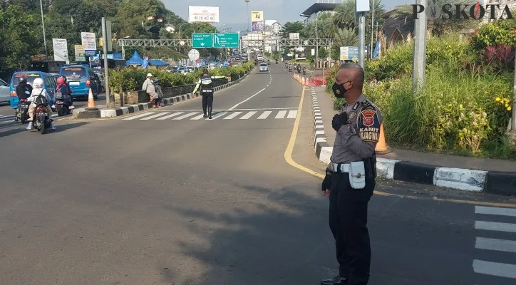 Kanit Turjawali Satlantas Polres Bogor, Ipda Ardian melakukan pengamanan di jalur Puncak Simpang Gadog setelah dibuka dua arah kembali. (foto: poskota/angga pahlevi)