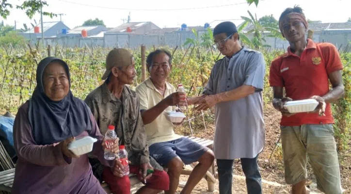 Ketua Sejadah Babe, Agus Sentosa membagikan nasi kotak dan air mineral botol kepada warga tidak mampu yang ditemuinya di Babelan, Bekasi. (foto: ist)