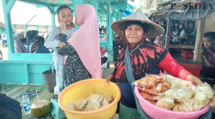 Ibu Surti berdagang emping di pantai. (foto: poskota/agus johara)