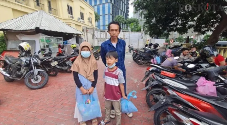 Narso (44) dan kedua anaknya saat datang ke Polsek Tanjung Duren untuk menerima bantuan. (foto: Cr01)