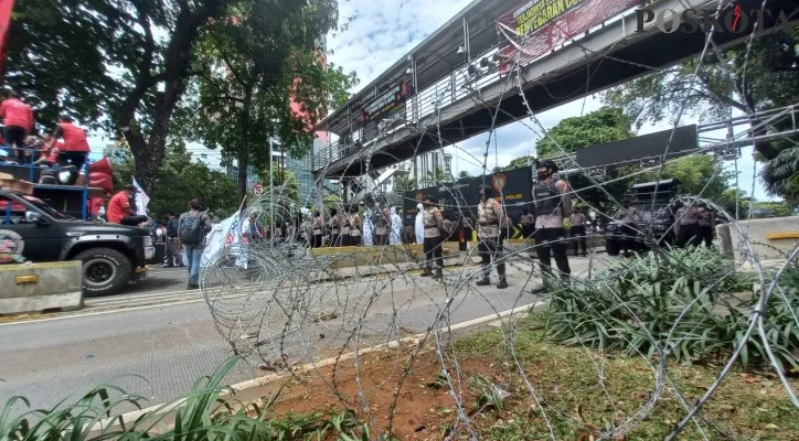 Pentupan jalan Medan Merdeka Barat, Gambir, Jakarta Pusat dengan menggunakan kawat berduri imbas adanya aksi unjuk rasa ribuan buruh. (foto: poskota/cr05)