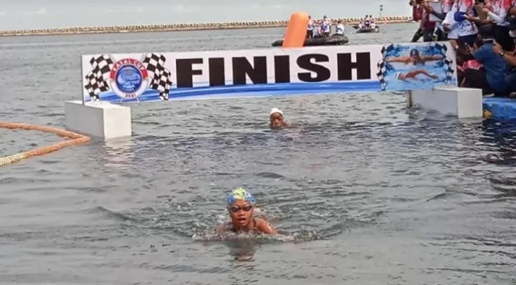 Kayla Nadia Shafa (12) saat mencapai Finish dalam kejuaraan renang dua kilometer Kasal Cup 2021 di Pantai Festival Ancol, Sabtu (27/11/2021). (foto: yono)