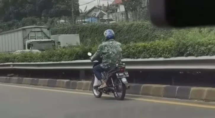 Pemotor berjaket loreng nekat masuk Tol JORR Jatiwarna, Bekasi, Senin (6/12/2021). (Foto/Tangkapan Layar/Instagram/@jktinfo)