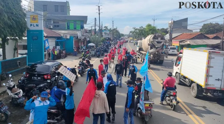 Buruh Aliansi Rakyat Tangerang Raya (Altar) membuat rantai manusia di Jalan Raya Serang, Kabupaten Tangerang, Banten. (foto: poskota/veronica)