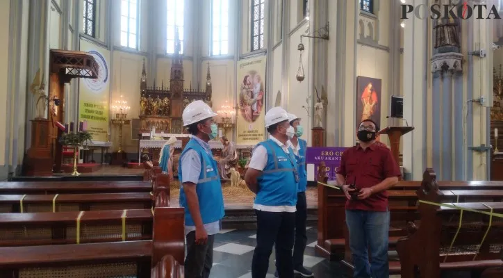 Building Manager Gereja Katedral Jakarta, Gervasius Saksono (kemeja merah) saat menemani General Manager PT PLN UID Jakarta Raya, Doddy B. Pangaribuan meninjau pasokan listrik di untuk perayaan Natal di Gereja Katedral Jakarta, Rabu (22/12/2021). (foto: poskota/cr10)