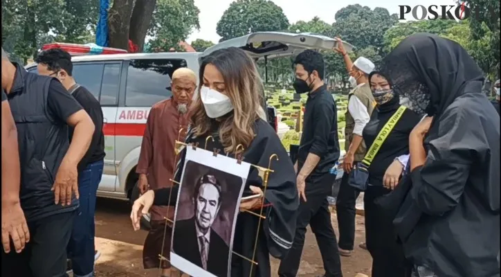 Nirina Zubir saat membawa foto sang ayah menuju pemakaman. (foto: poskota/cr07)