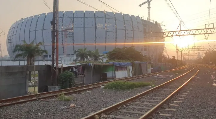 Deretan bedeng berjejer di pinggiran rel berdampingan dengan jalur kereta aktif.