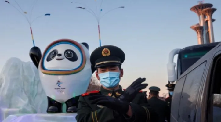 Petugas polisi paramiliter memberi isyarat kepada fotografer di depan maskot Olimpiade Musim Dingin Beijing 2022 di Beijing Tiongkok pada 15 Januari 2022. (Sumber: Reuters)