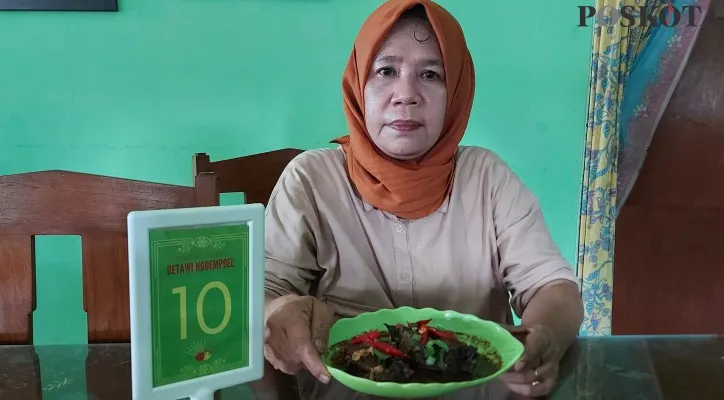 Juru Masak di Betawi Ngumpul, Herlina (58), akrab disapa Mpo Lina memperlihatkan masakan Gabus Pucung menambah selera makan. (foto: poskota/angga pahlevi)