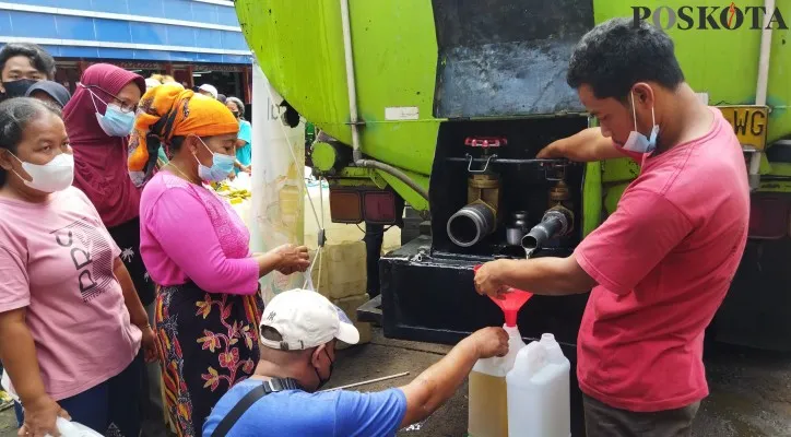 Warga yang datang ke area parkir Pasar Kramat Jati, Jakarta Timur, guna mendapat minyak goreng murah yang dialirkan dari truk tangki, Kamis (3/2/2022). (Ardhi)