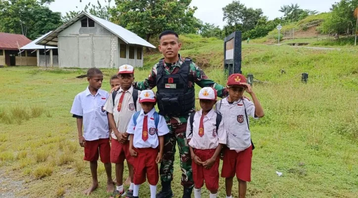 Satgas Pamtas Yonif 126/KC saat membantu siswa di perbatasan RI - PNG untuk menuju sekolah. (foto: Satgas Pamtas Yonif 126/KC)