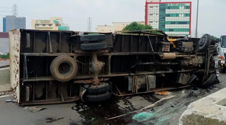 Kondisi mobil truk wing box bernomor polisi B 9379 UXU usai menghantam pembatas jalan tol Ancol hinga terbalik. (Foto: Sat Lantas Jakarta Utara)