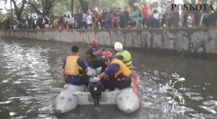 Petugas Gulkarmat Jakarta Barat sedang melakukan pencarian terhadap jasad Fais yang tenggelam di Kali Semanan. (foto:poskota)