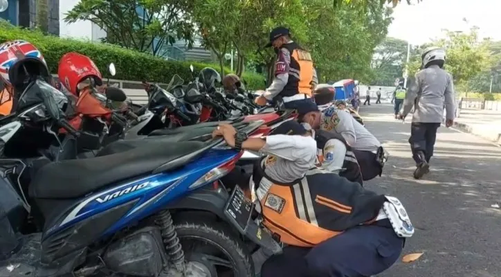 Petugas saat menertibkan parkir liar di kawasan Kembangan Jakbar. (foto: Ist)