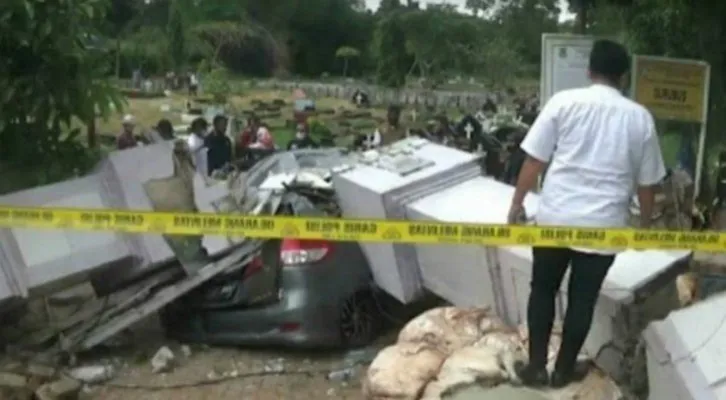 Mobil sedan remuk tertimpa gapura TPU Garubug,di Kelapa Dua, Kabupaten Tangerang. (Foto/Veronica)