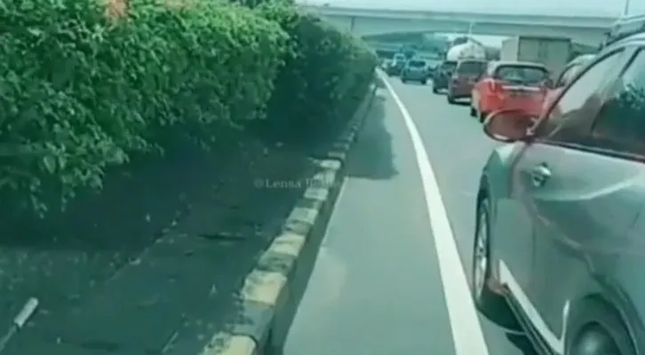 Tangkapan layar video yang menampilkan mobil pribadi bermerek Honda HRV menghalangi laju mobil ambulans di Jalan Tol Dalam Kota, Cawang, Jakarta Timur. (foto: instagram/@lensa_berita_jakarta)