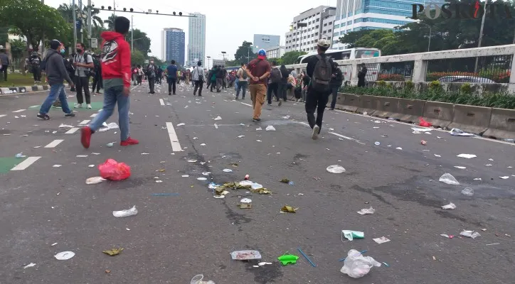 Pasca demo mahasiswa tampak sampah berserakan di jalan depan gedung DPR RI. (foto: poskota/pandi)