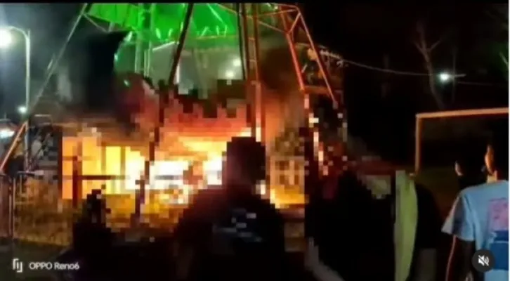 Tangkapan layar video wahana perahu Kora-kora yang terbakar di sebuah pasar malam di Tuban, di atas tersebut masih ada pengunjung yang terlanjur naik. (Foto: tangkapan layar instagram/Terangmedia)