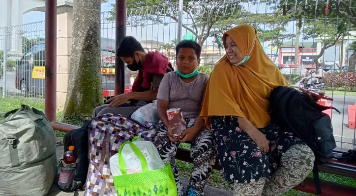 Nur Aini bersama dua anaknya di Pospam Citra Raya, Kabupaten Tangerang, Jumat (29/4/2022). (foto: poskota/ iqbal)