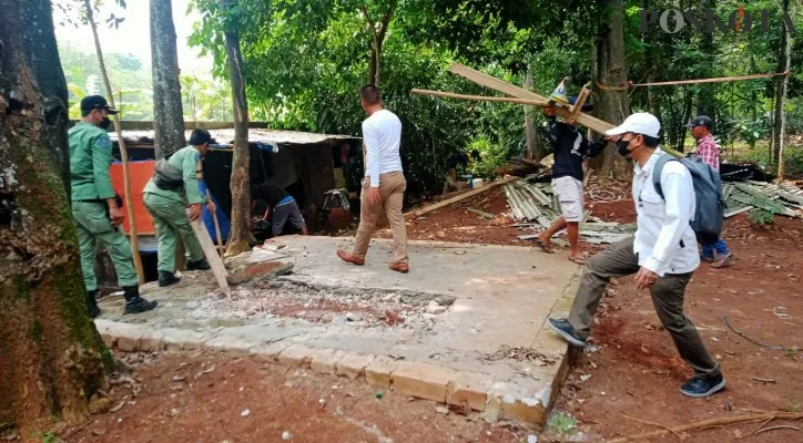 Petugas gabungan dari Satpol PP dan polisi Polsek Maja membongkar makam keramat yang diduga digunakan ritual alirat sesat di Kecamatan Maja, Lebak, Banten. (foto; poskota/yusuf permana)