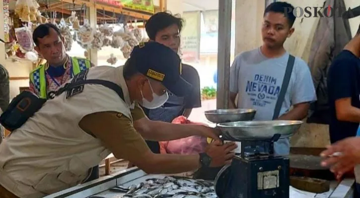 Petugas saat melakukan pengecekan dan tera ulang timbangan di Pasar Cisoka. (Foto:poskota/Veronica)