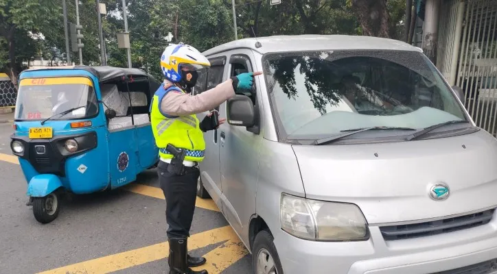 Petugas Ditlantas Polda Metro Jaya melakukan teguran terhadap pelanggar ganjil genap. (Ist)