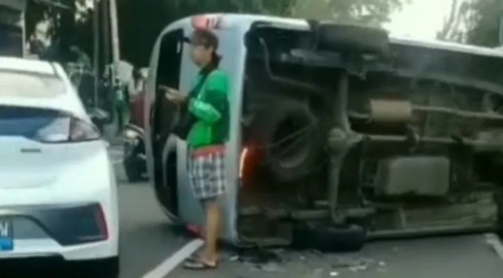 Minibus terguling setelah tabrak tiang penerangan di Jalan Raya Lenteng Agung, Jakarta Selatan. (foto: ist)