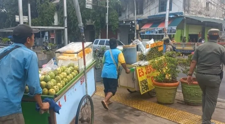 PKL di kawasan wisata Kota Tua, Jakarta Barat, didorong Satpol PP untuk menempati Lokbin. (foto: poskota/pandi)