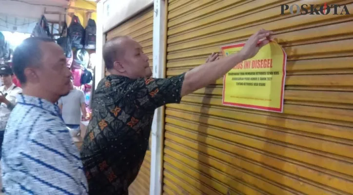 Diskoperindag saat menyegel kios di Pasar Badak, Pandeglang yang tak mau membayar tunggakan sewa. (foto: poskota/samsul fatoni)