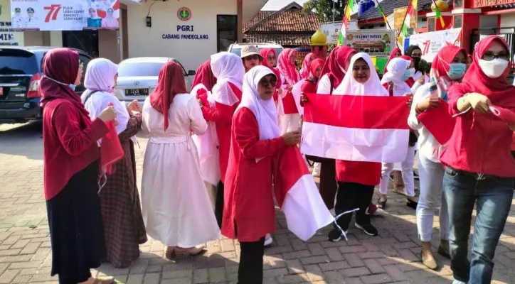 Dewan Guru dan siswa SDN Pandeglang 4 saat bagikan bendera merah putih pada warga. (foto: ist)