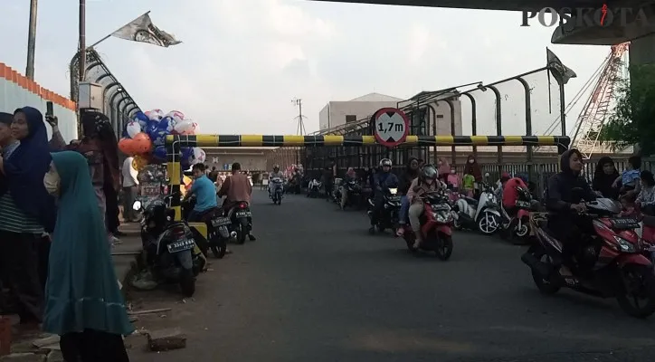 Masyarakat tampak menikmati pemandangan sore hari dari Jembatan Anteilope Lama. (foto: poskota/ihsan)