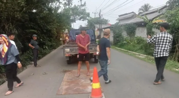 Petugas dari UPT Bina Marga Banten saat melakukan penambalan jalan Panimbang-Munjul. (Foto: Ist).