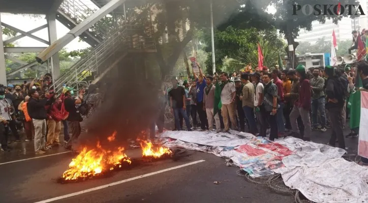 Mahasiswa bakar ban bekas saat demo tolak kenaikan BBM di kawasan Patung Kuda, Jakarta Pusat. (foto: poskota/aldi)