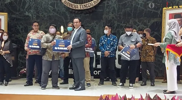 Wartawan Poskota Ahmad Tri Hawari saat menerima penghargaan juara 1 Anugerah Jurnalistik MH. Thamrin yang diberikan Gubernur DKI Jakarta, Anies Baswedan. (foto: poskota/aldi)