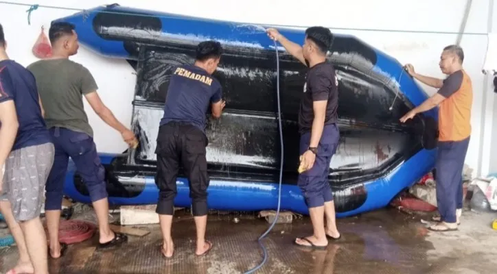 Anggota BPBD Kabupaten Tangerang saat melakukan perawatan perahu karet. (foto: ist)