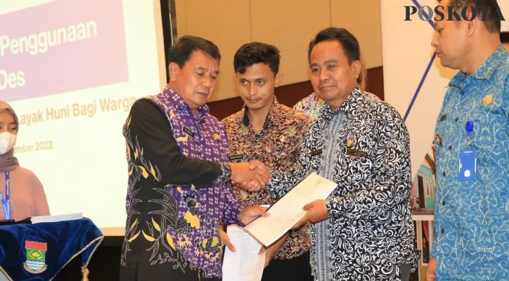 Sekda Kabupaten Tangerang, Moch Maesal Rasyid secara simbolis memberikan buku panduan penggunaan APBDes. (foto: poskota/veronica)