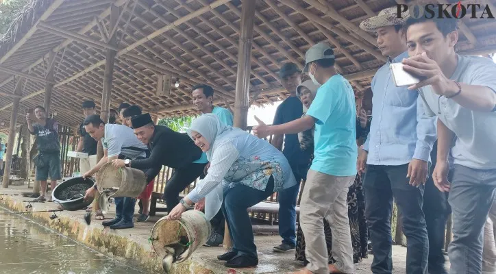 Bupati Pandeglang, Irna Narulita saat menabur ikan di acara lomba mancing pada Milad Porwan ke-1. (Foto: Samsul Fatoni)