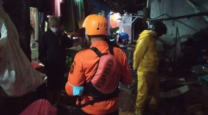 Petugas BPBD Kota Bekasi saat berada di lokasi rumah roboh akibat hujan lebat. (foto: ist)